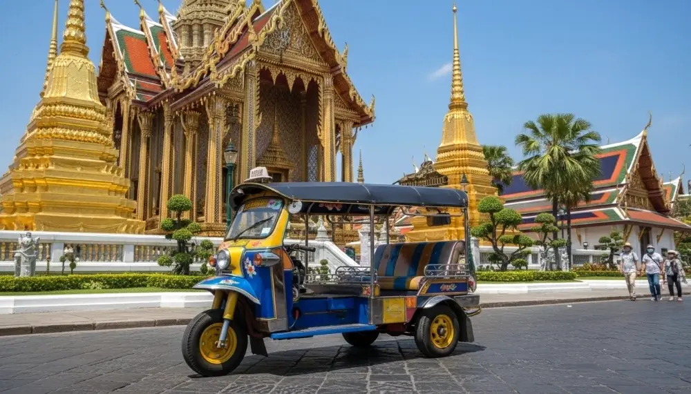 tuk tuk in front of golden Thai temple