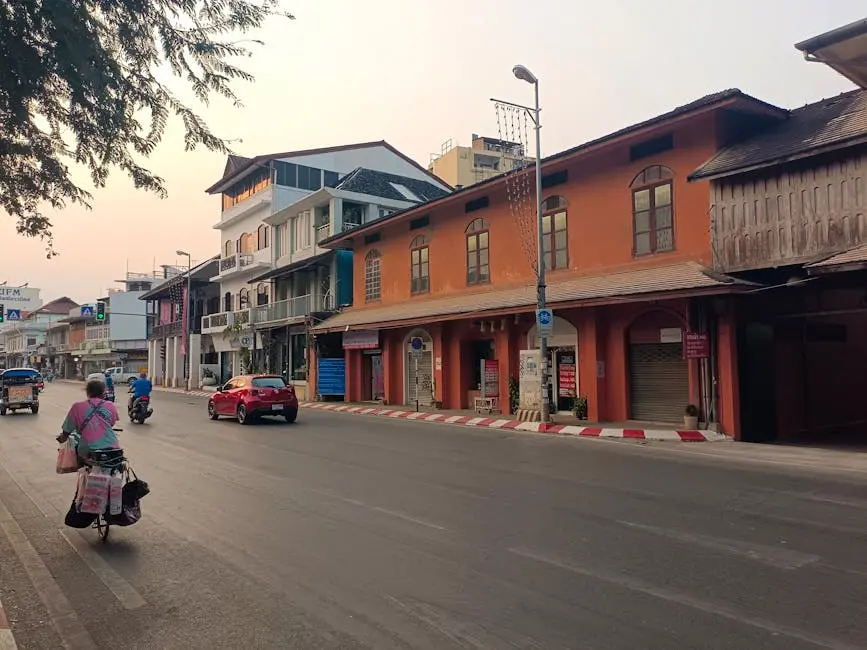 A Lively Street In Chiang Mai With People And Vehicles Under The Soft