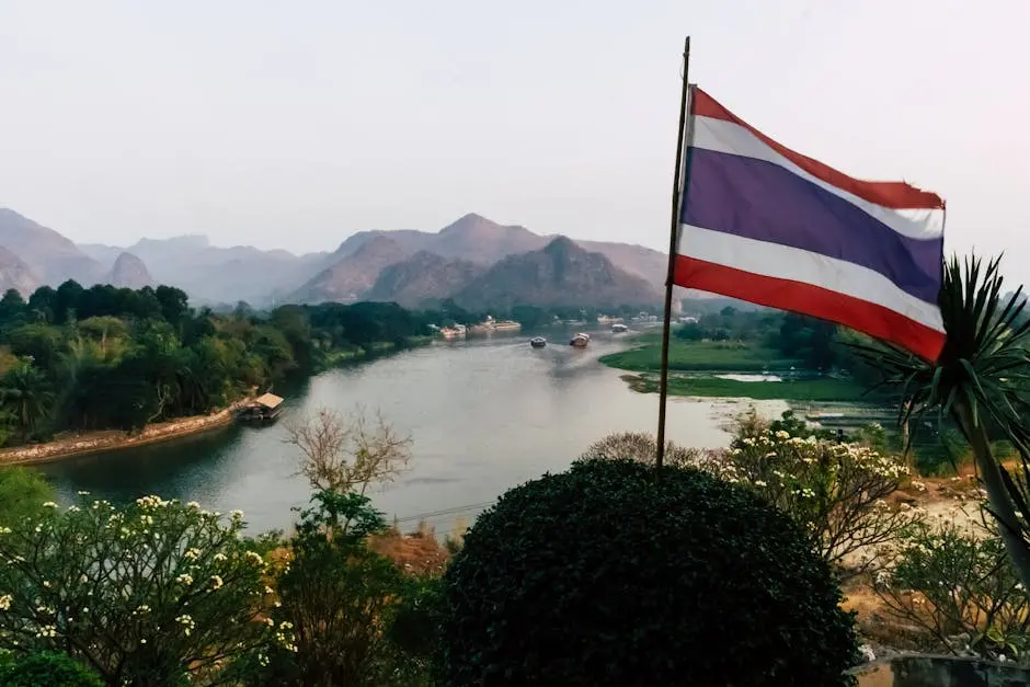 A Picturesque River Flowing Through The Lush Mountains Of Kanchanaburi