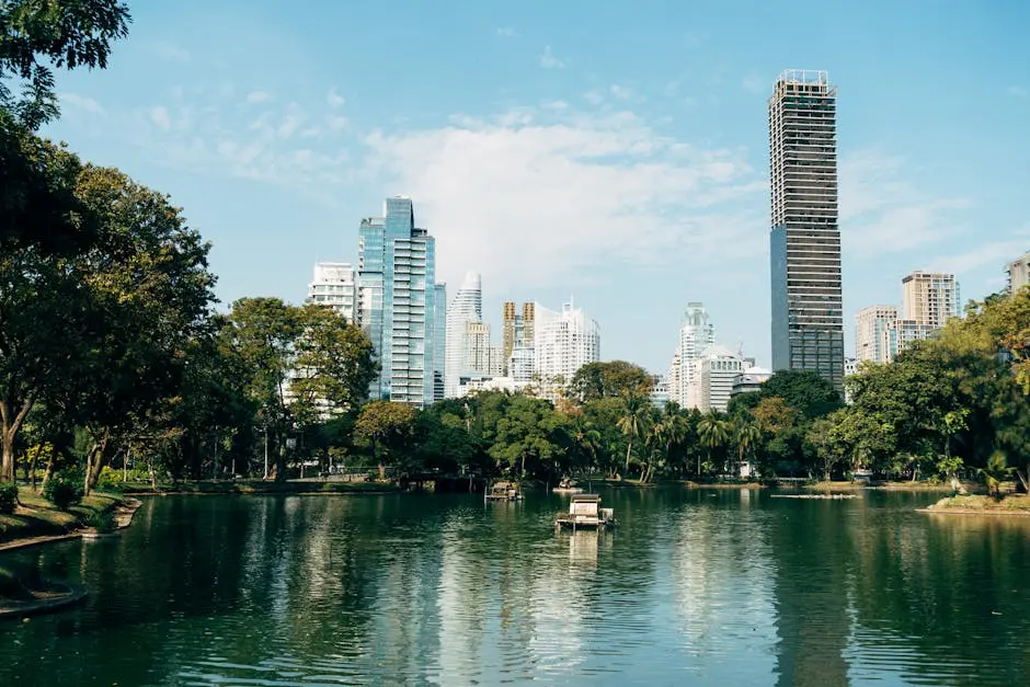 Cityscape View Of Bangkok S Skyline Reflecting In A Peaceful Park Lake