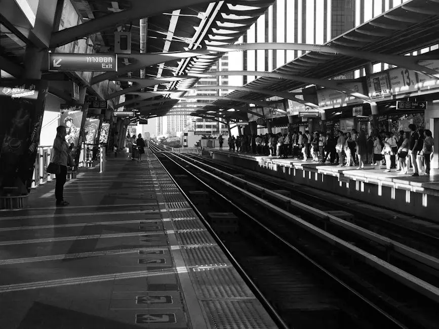 Commuters Waiting On A Bangkok Train Station Platform In Grayscale Lig