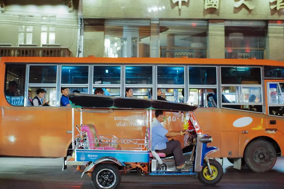 Dynamic Street View Of Bangkok Showcasing A Tuk Tuk And Bus With Passe