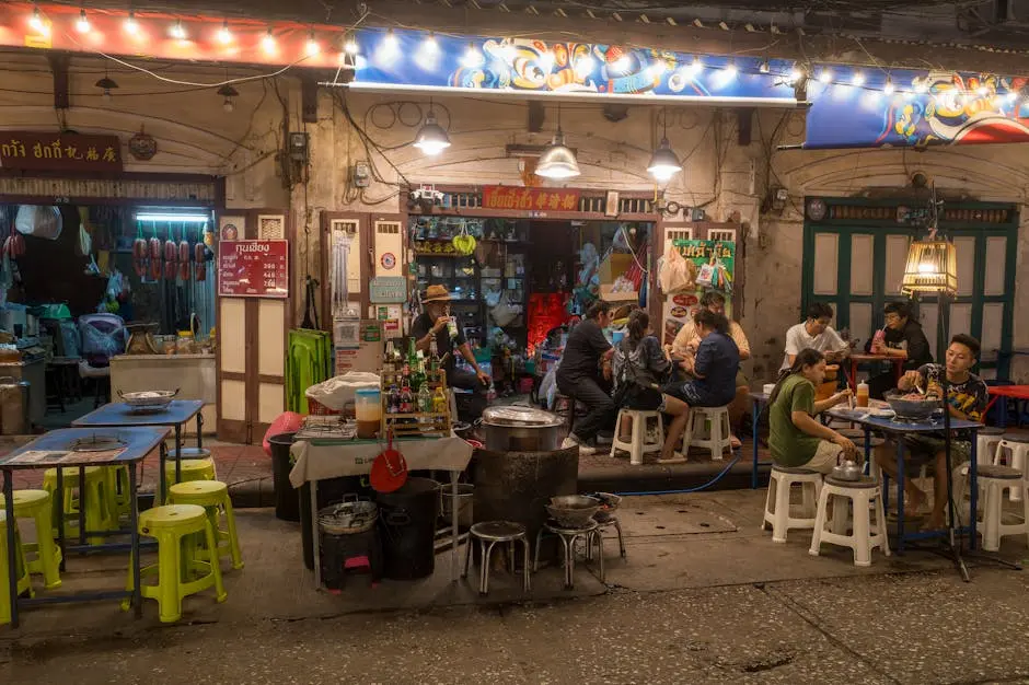 Nighttime Street Food Scene In Bangkok With People Dining Outdoors Und