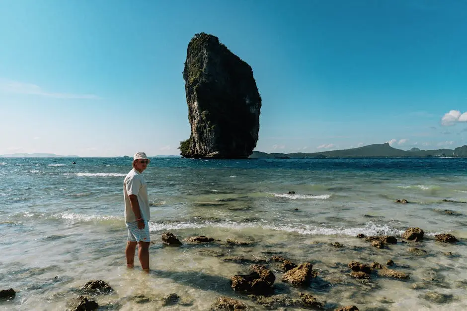 Person On A Tropical Beach With A Massive Limestone Rock In The Backgr