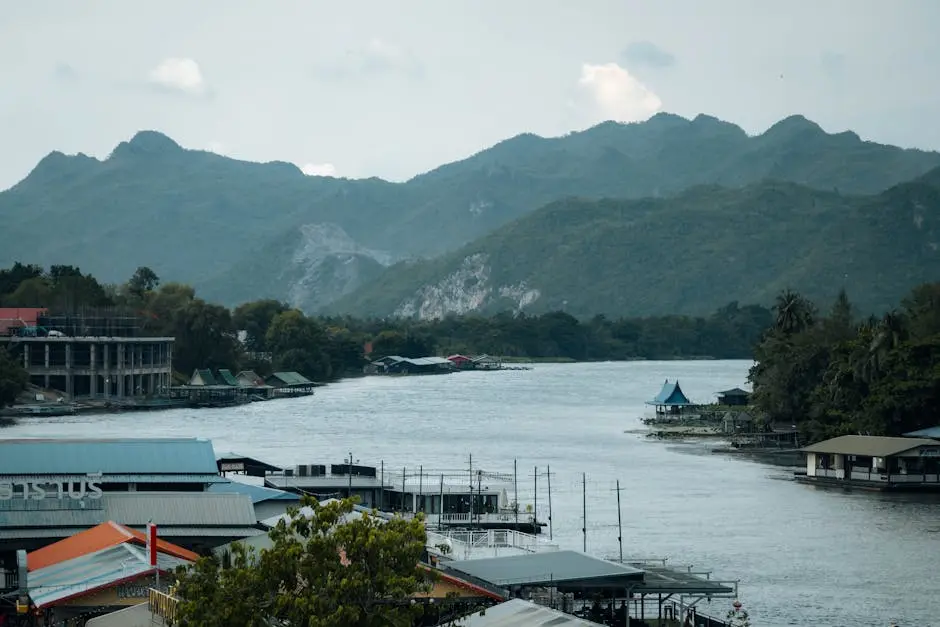 Picturesque View Of The Riverside In Kanchanaburi Thailand With Mounta