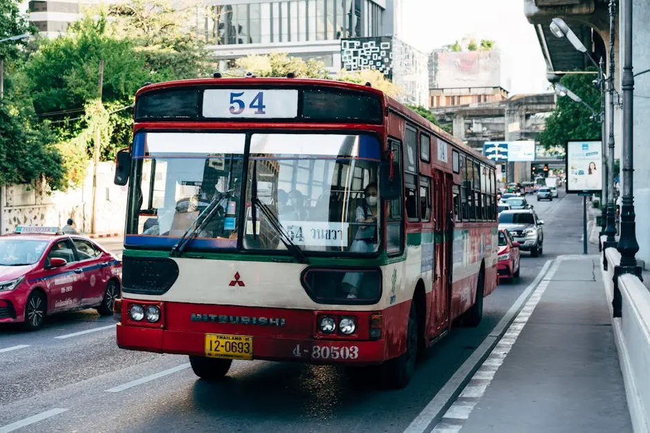 Red Bus And Bustling City Traffic On A Sunny Day In Bangkok Thailand