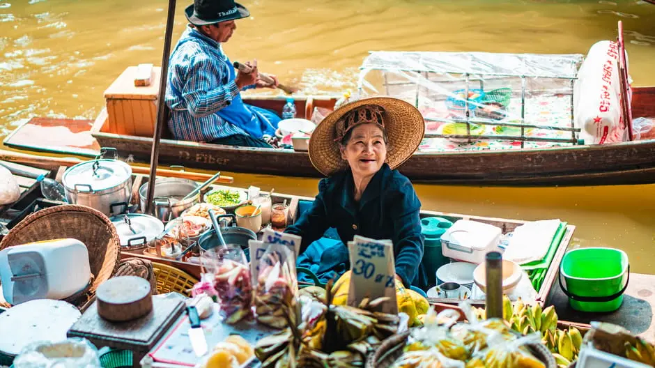 Smiling Vendor At Bangkok S Floating Market Selling Fresh Produce And
