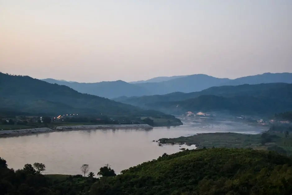 Tranquil View Of The Mekong River At Sunset With Lush Hills In Chiang