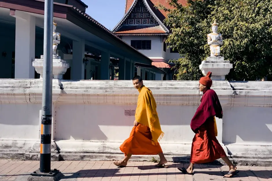 Two Monks In Traditional Robes Walk By A Temple In Chiang Mai Thailand